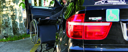 Photo d'un handicapé entrant dans sa voiture