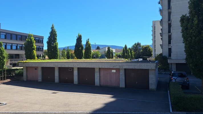 Rangée de garages avec une toiture végétalisée à Delémont