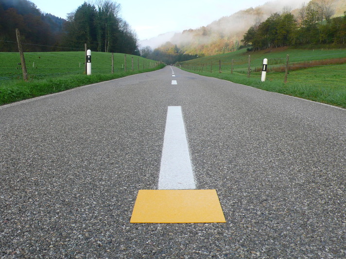 Les axes du réseau routier jurassien sont équipés de carrés jaunes (Points de Repère - PR) placés au milieu de la route à un intervalle d’environ 250 mètres