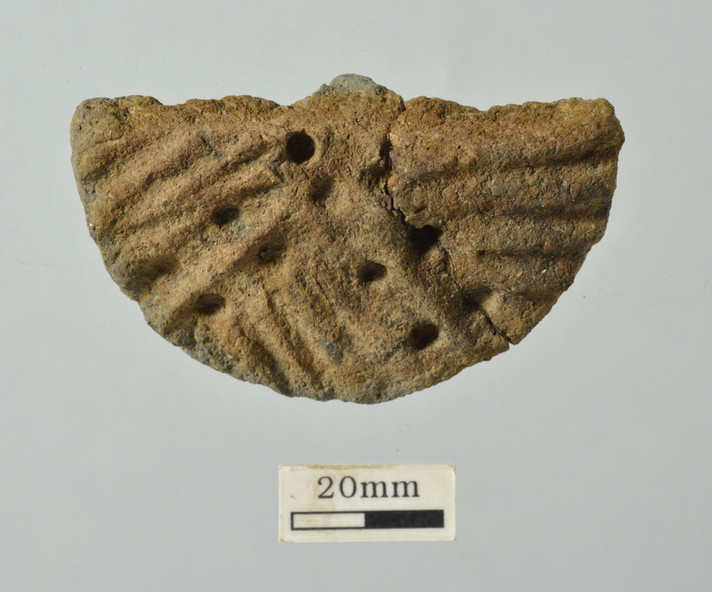 Couvercle décoré retrouvé à Delémont-Communance Sud, datant de l'âge du Bronze (env. 1000 av. J.-C.)