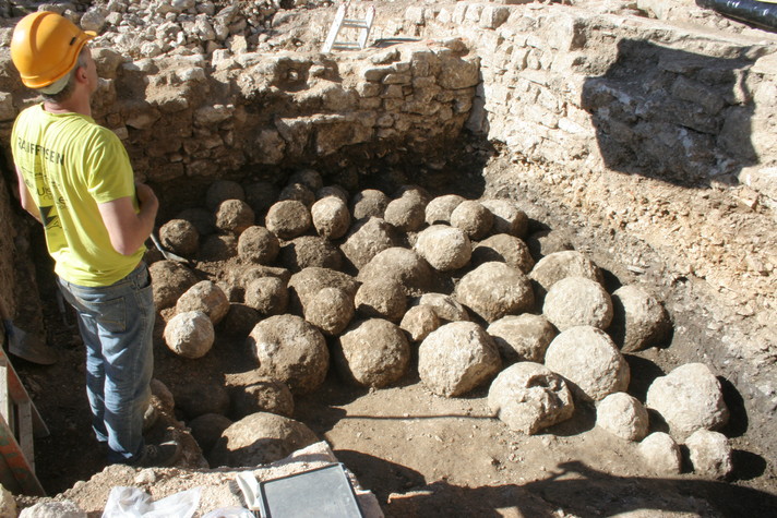 Les boulets de trébuchet en cours de dégagement par un collaborateur de l'Archéologie cantonale. Photo OCC-SAP