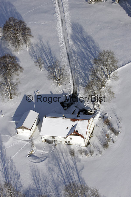 Photo aérienne d'une ferme en hiver dans les Franches-Montagnes