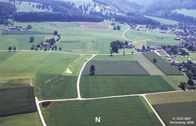 Vue aérienne de l'emplacement du site (flèche), avant le début des fouilles archéologiques.