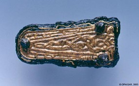 Contre-plaque en fer et laiton décorée d'un motif zoomorphe.